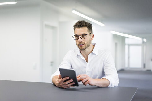 Geschäftsmann benutzt Tablet im Büro - MOEF02247