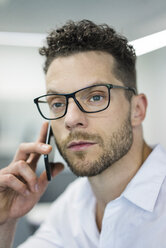Portrait of businessman on cell phone in office - MOEF02250