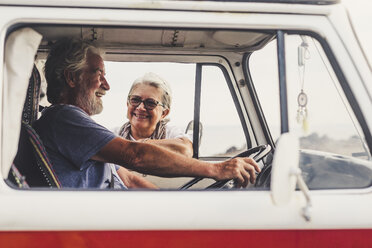 Senior couple traveling in a vintage van, taking a break at the sea, talking - SIPF01993