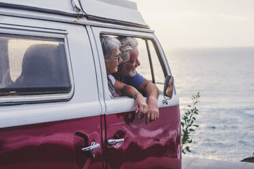 Senior couple traveling in a vintage van, looking at the sea - SIPF02002