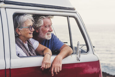 Senior couple traveling in a vintage van, looking at the sea - SIPF02004