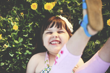 Smiling girl playing in grass with flowers, - BLEF05834