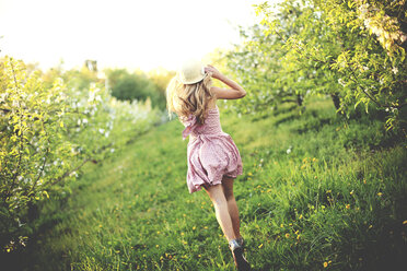 Frau, die in einem ländlichen Obstgarten spazieren geht - BLEF05844