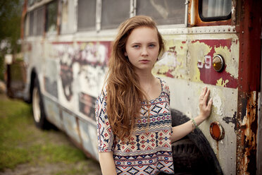 Kaukasisches Teenager-Mädchen steht in der Nähe des baufälligen Busses - BLEF05862