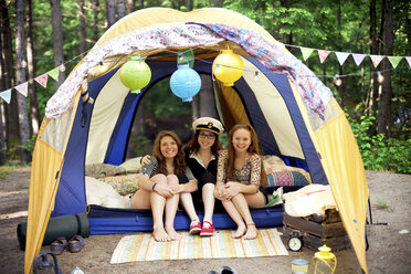 Girls relaxing in camping tent stock photo