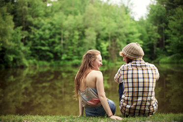 Rear view of couple sitting near lake - BLEF05911