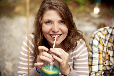 Close up of girl drinking beverage with straw - BLEF05920