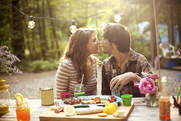 Paar reibt sich die Nasen am Picknicktisch im Wald - BLEF05922