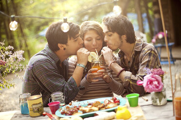 Freunde teilen sich eine Limonade am Picknicktisch im Wald - BLEF05924