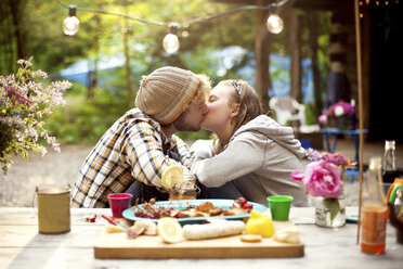 Paar küsst sich am Picknicktisch im Wald - BLEF05925