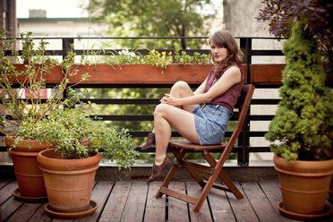 Teenage girl sitting on urban rooftop - BLEF05940