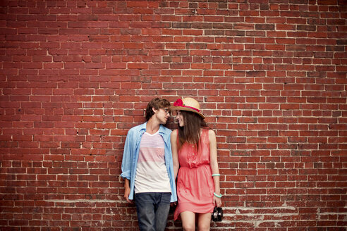 Couple leaning on brick wall - BLEF05948