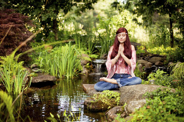 Girl meditating near rural creek - BLEF05981
