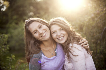 Smiling women hugging in rural field - BLEF05989