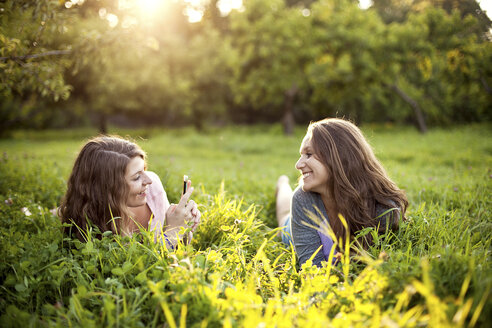 Kaukasische Frauen, die auf einem ländlichen Feld liegen - BLEF05996