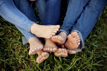 Close up of feet of friends in grass - BLEF06014
