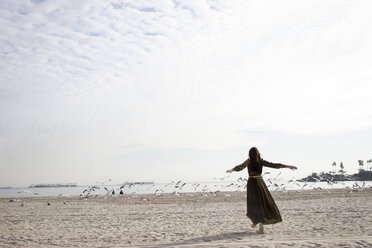 Frau im Kleid spielt am Strand - BLEF06036