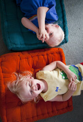 Brother and sister playing on cushions on floor - BLEF06038