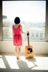 Asian woman holding guitar in window - BLEF06059