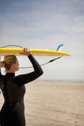 Surfer trägt Surfbrett am Strand - BLEF06085