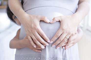 Hispanisches Mädchen hält Bauch der schwangeren Mutter - BLEF06116