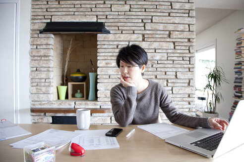 Japanische Frau bezahlt Rechnungen am Laptop - BLEF06153