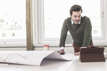 Junger Architekt arbeitet an einem Entwurf in einem hellen Büro - UUF17727