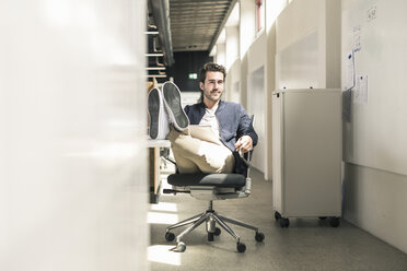 Junger Geschäftsmann arbeitet entspannt in einem modernen Büro, - UUF17803