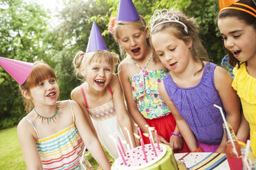 Mädchen bewundern Kuchen bei Geburtstagsfeier im Freien - BLEF06237