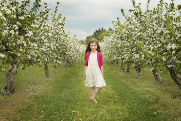 Kaukasisches Mädchen geht in blühendem Obstgarten - BLEF06259