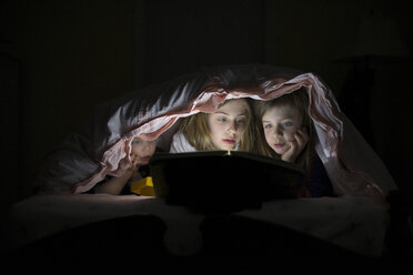 Kaukasische Schwestern benutzen Laptop in einer Decke für die Nacht - BLEF06270