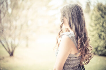 Caucasian teenage girl with curly hair outdoors - BLEF06351