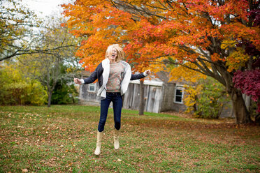 Caucasian woman jumping for joy in backyard - BLEF06387