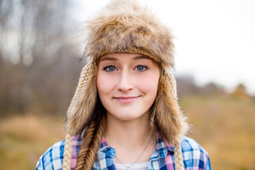 Caucasian teenage girl wearing fur hat in field - BLEF06397