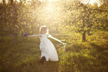 Caucasian girl spinning in grass - BLEF06412