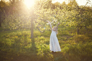 Caucasian girl tossing flower petals outdoors - BLEF06415