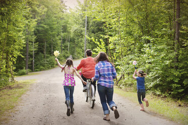 Three generations of Caucasian women walking on dirt road - BLEF06435