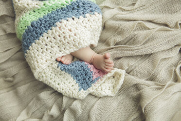 Nahaufnahme der Füße eines neugeborenen Babys, eingewickelt in eine Decke - BLEF06477