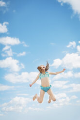 Caucasian girl jumping for joy in blue sky - BLEF06479