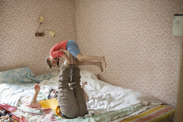 Caucasian father and daughter playing on bed - BLEF06500