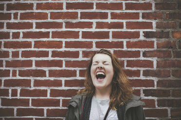 Caucasian woman shouting at brick wall - BLEF06631