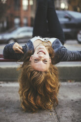 Caucasian woman laying on city sidewalk - BLEF06642