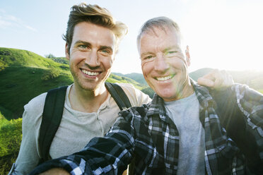 Kaukasischer Vater und Sohn machen ein Selfie auf einer ländlichen Hügelkuppe - BLEF06654
