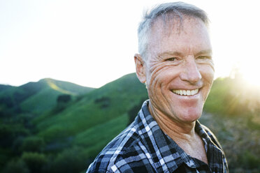 Older Caucasian man smiling on rural hilltop - BLEF06660
