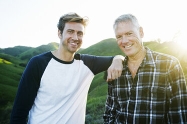 Caucasian father and son smiling on rural hilltop - BLEF06661