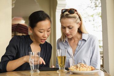 Geschäftsfrauen benutzen ein digitales Tablet in einem Cafe - BLEF06664