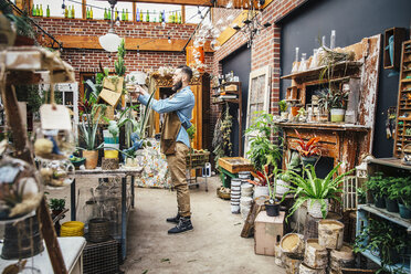 Caucasian employee watering plants in nursery - BLEF06680