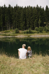 Vater und Tochter sitzen am Seeufer, Jochberg, Österreich - PSIF00279