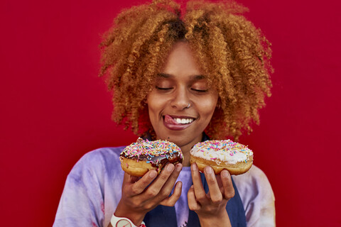 Woman choosing which donut to eat stock photo