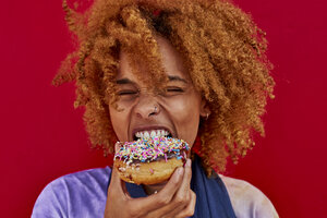 Porträt einer Frau, die einen Donut isst - VEGF00285